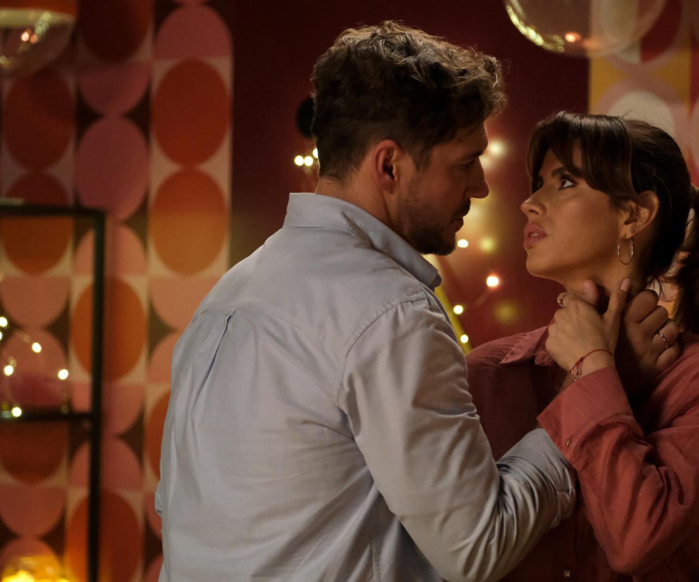 Marcin Chodakowski (Mikołaj Roznerski) i Kama (Michalina Sosna) z M jak miłość patrzą sobie w oczy w intymnym zbliżeniu, on w jasnej koszuli, ona w różowej, z rękami na szyi mężczyzny. Ich gesty sugerują napięcie lub namiętność w 1919 odcinku. Więcej o ich losach na Super Seriale.