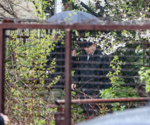 Pięciu ochroniarzy prowadzi Kaczyńskiego do bramy