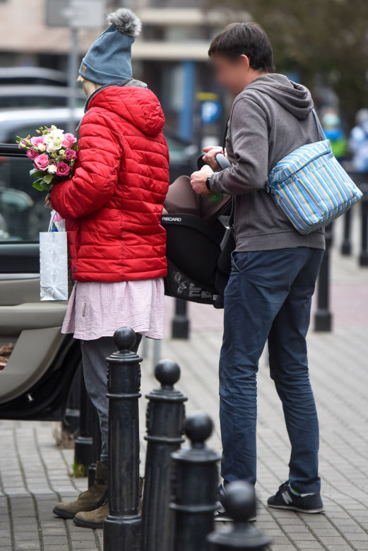 Joanna Moro z mężem i dzieckiem wychodzą po porodzie ze szpitala