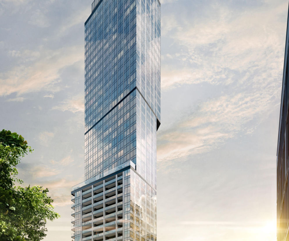 Wysoki, szklany wieżowiec Liberty Tower w Warszawie przy słonecznym niebie. O projekcie budynku przeczytasz na Mediateka.