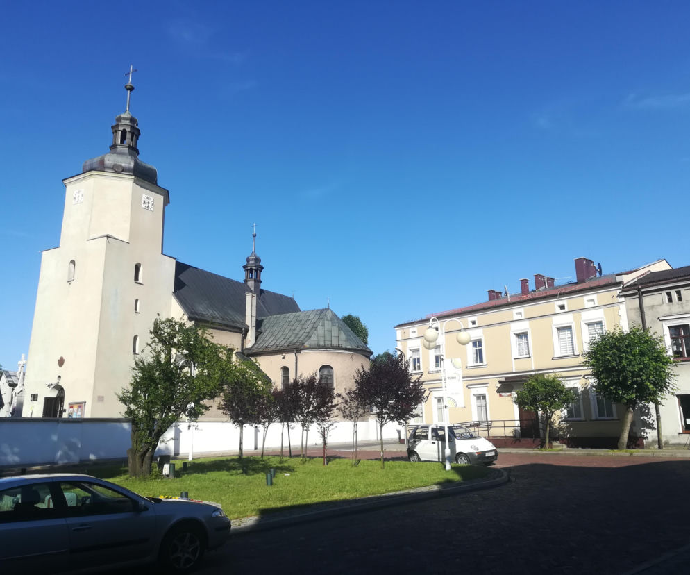 Zabytkowy kościół św. Katarzyny w Woźnikach obok kamienic przy Rynku. O urokach miasta przeczytasz na Eska Śląskie.