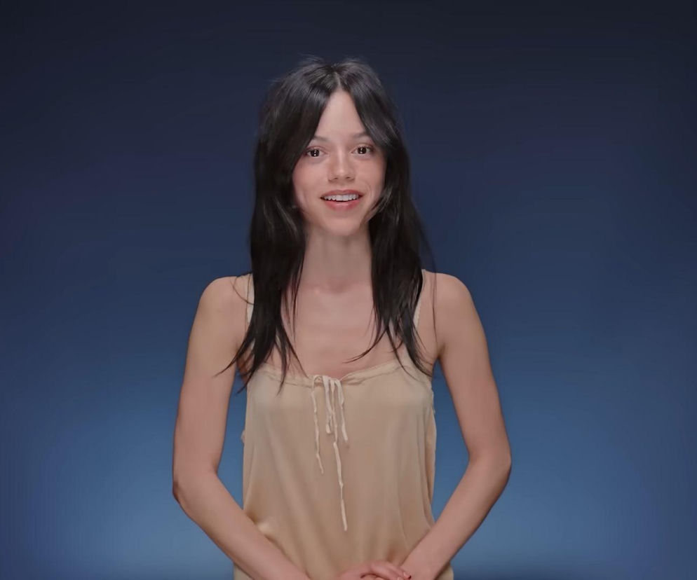 Aktorka Jenna Ortega w beżowej koszulce na ciemnym tle. O metamorfozie gwiazdy Wednesday przeczytasz na Eska.
