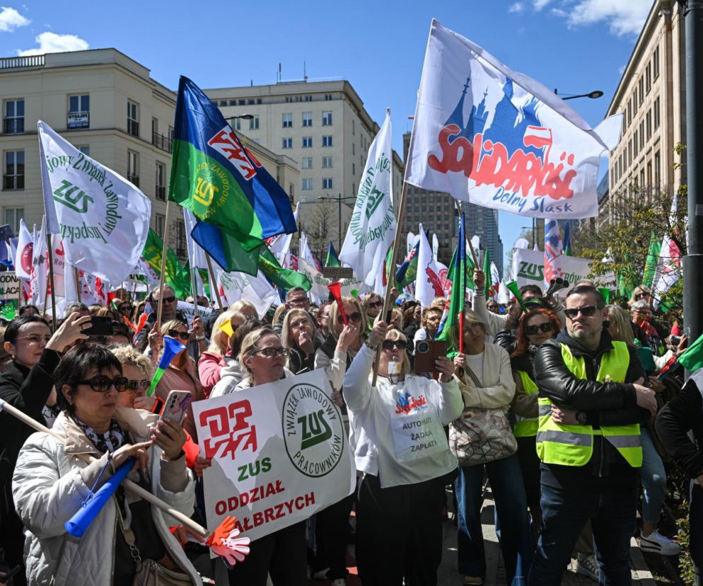 Protest pracowników ZUS w Warszawie przed Ministerstwem Finansów, domagających się podwyżek. Liczny tłum trzyma transparenty ZUS Oddział Wałbrzych i flagi Solidarności. Zdjęcie ilustruje spór o wynagrodzenia, o którym przeczytasz na Super Biznes.