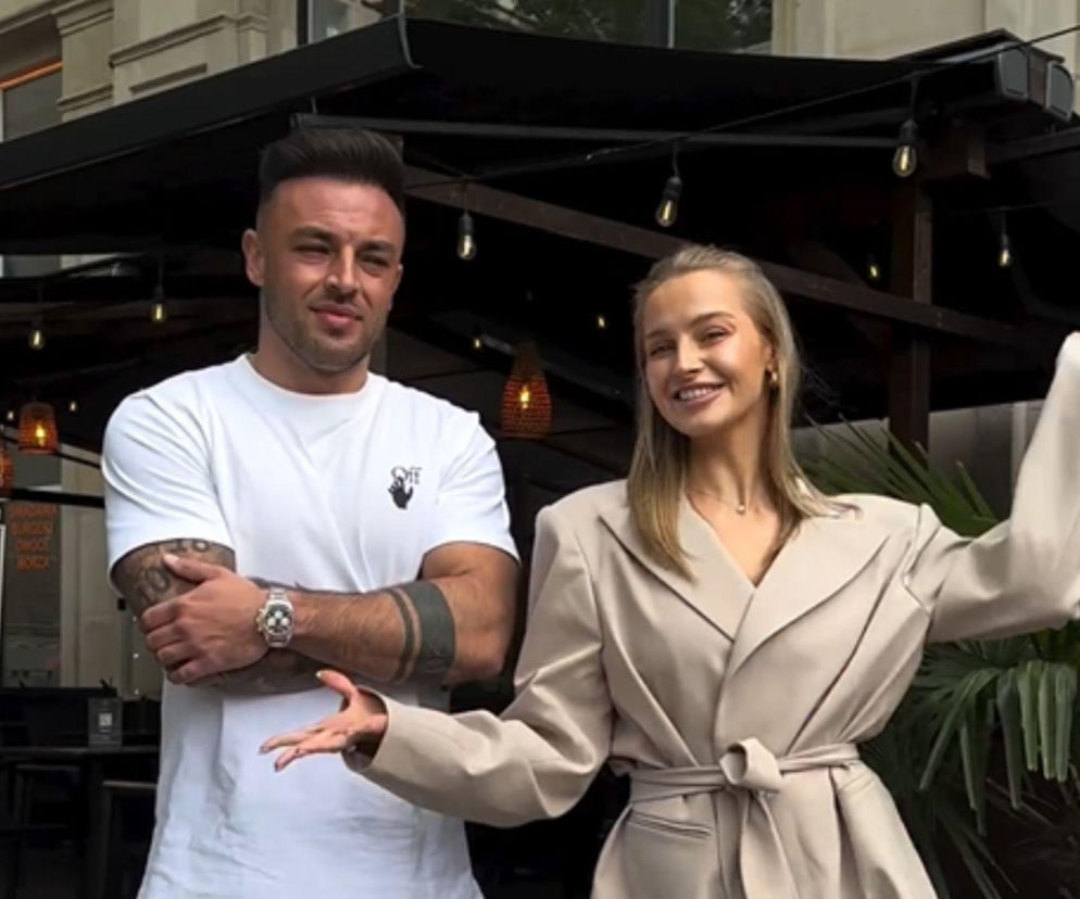 Karolina Pisarek i Roger Salla stoją uśmiechnięci przed lokalem. O narodzinach ich córki Kiary przeczytasz na SE.