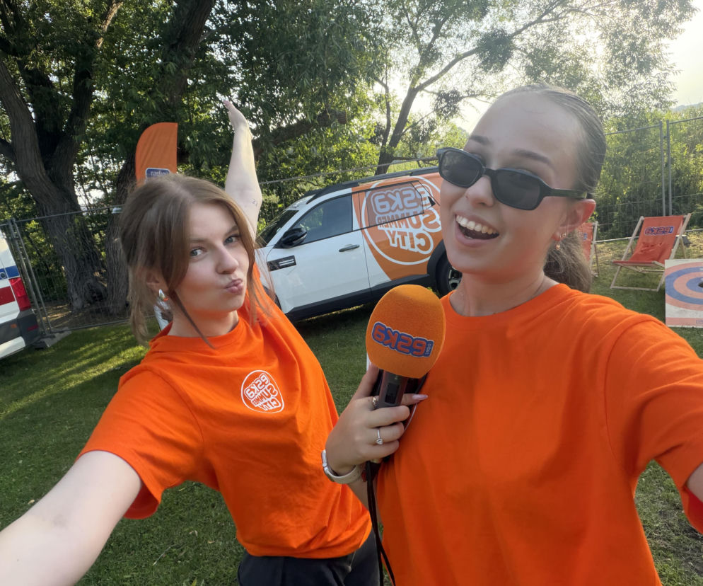 Dwie uśmiechnięte reporterki w pomarańczowych koszulkach Eska Summer City w Szczytnie. Relacja w Eska Olsztyn.
