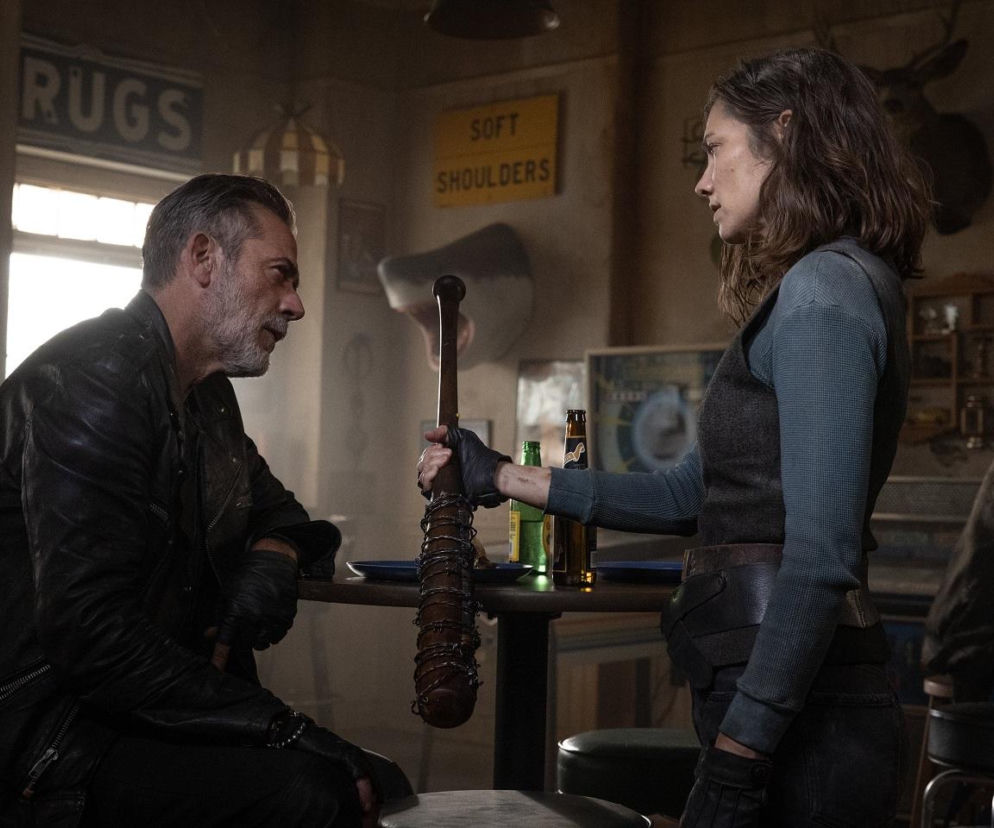 Maggie i Negan w postapokaliptycznym barze, gdzie Maggie trzyma owinięty drutem kij baseballowy. Scena z serialu The Walking Dead: Dead City, o którym przeczytasz więcej na naszym portalu. Para bohaterów przygotowuje się na nowe wyzwania w zrujnowanym Nowym Jorku.