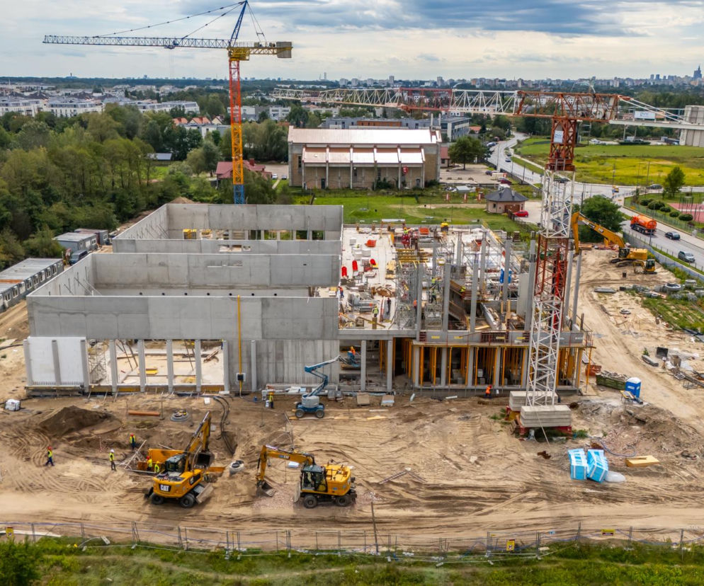 Plac budowy pływalni na Białołęce z żurawiami i koparkami. O nowym kompleksie sportowym przeczytasz w serwisie Architektura.