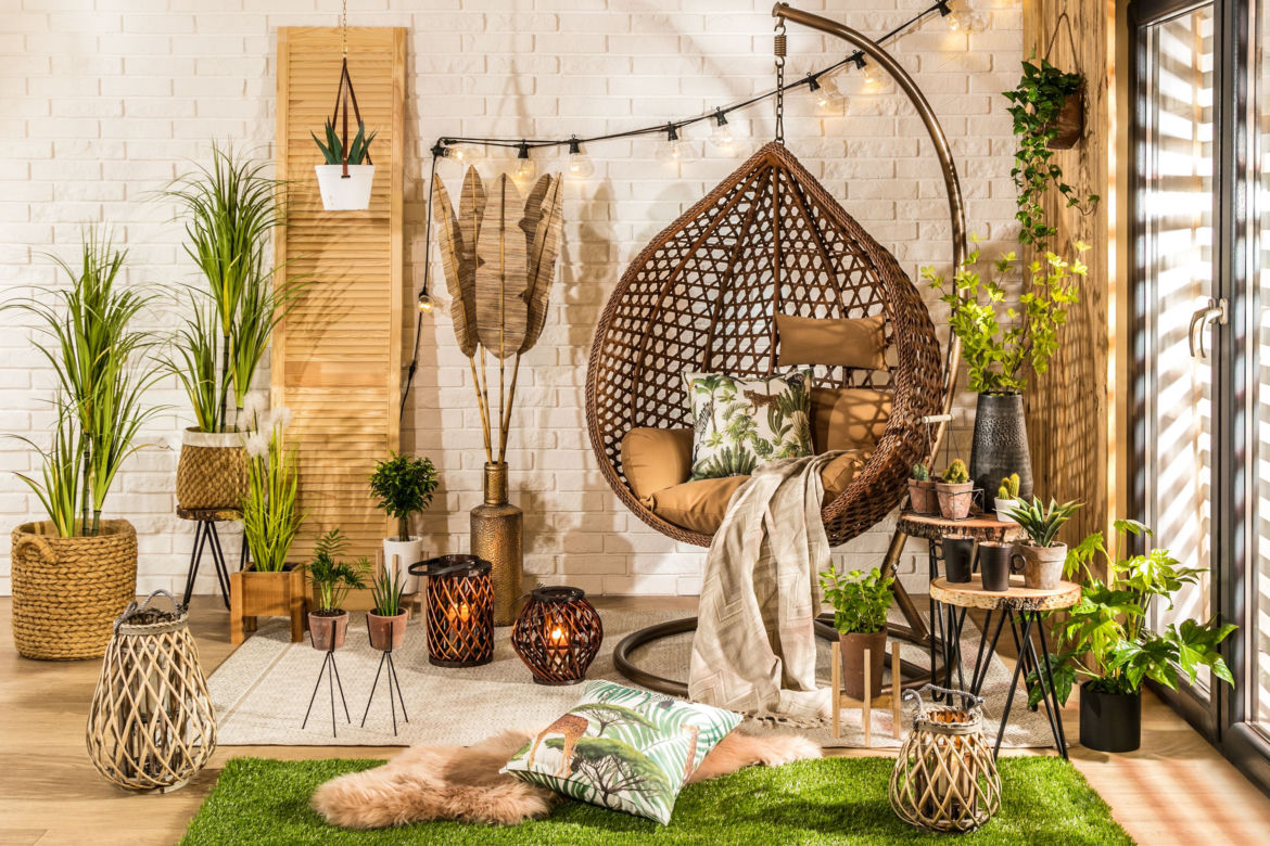 Mały balkon w bloku lub kamienicy z bogatym wystrojem w stylu boho