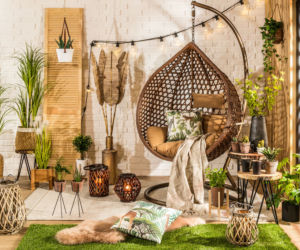 Mały balkon w bloku lub kamienicy z bogatym wystrojem w stylu boho