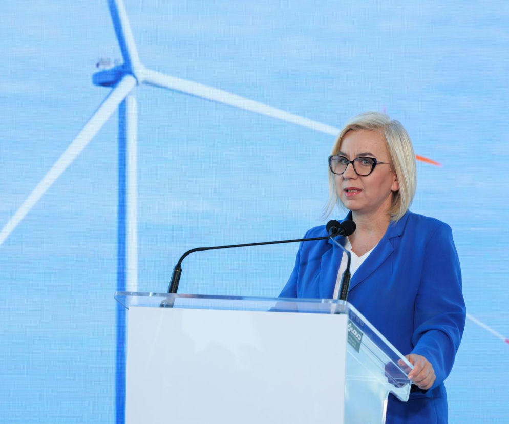 Minister Paulina Hennig-Kloska przemawia przy białej mównicy. O kaucji na małpki przeczytasz na SE Superbiz.