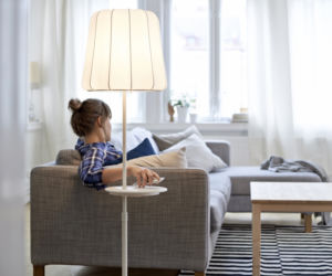 Lampa podłogowa z ładowarką ustawiona przy sofie