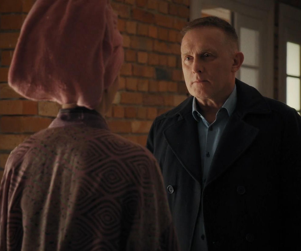 Artur (Robert Moskwa) i Joanna (Dominika Sakowicz) w dramatycznej scenie w serialu M jak miłość. Rogowski w granatowym płaszczu i błękitnej koszuli stoi naprzeciw Joanny w szlafroku i ręczniku na głowie, patrząc na nią z powagą. Więcej o ich losach na Super Seriale.