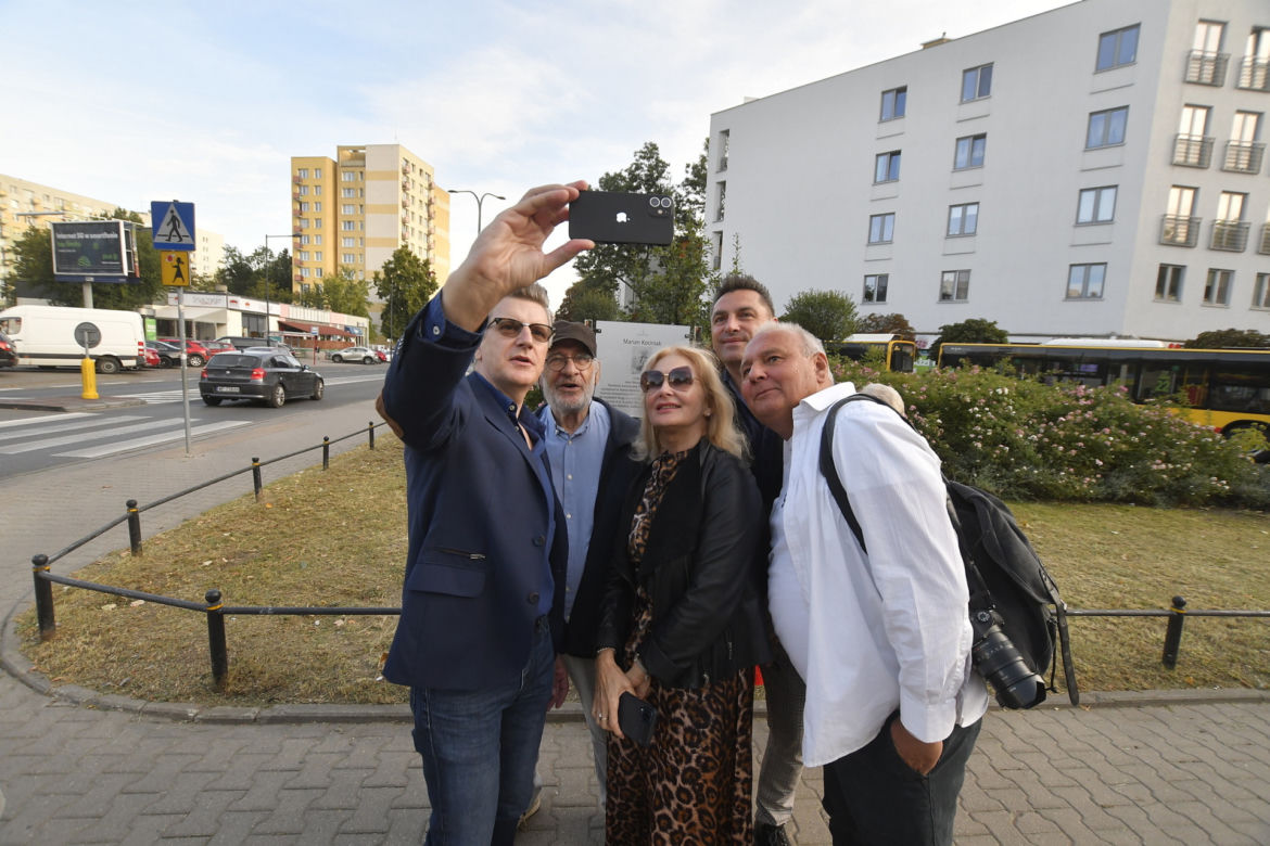 Pamiątkowe zdjęcie aktorskiej ekipy przy tablicy z nazwą ronda Mariana Kociniaka