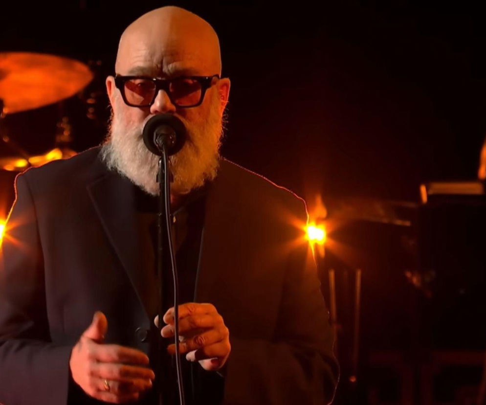 Michael Stipe śpiewa do mikrofonu na scenie. O jego debiutanckiej płycie przeczytasz na EskaRock.