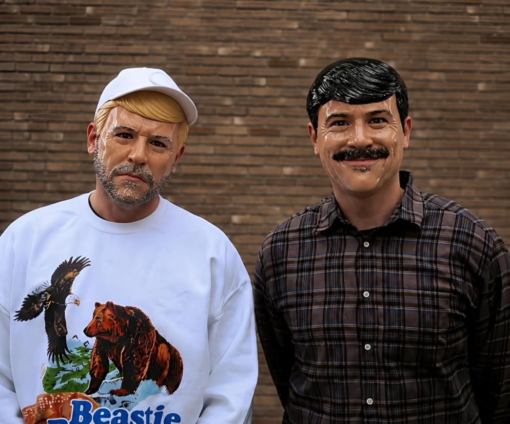 Dwie osoby w maskach na tle ceglanej ściany. O festiwalu artystycznym LUFA w Lesznie przeczytasz na Eska Leszno.