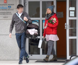Joanna Moro z mężem i dzieckiem wychodzą po porodzie ze szpitala