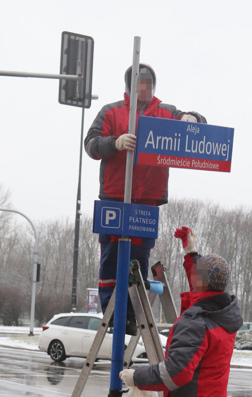 Dekomunizacja Warszawy. Zdejmowanie tablicy z Aleją Lecha Kaczyńskiego, zakładanie na powrót Armii Ludowej.