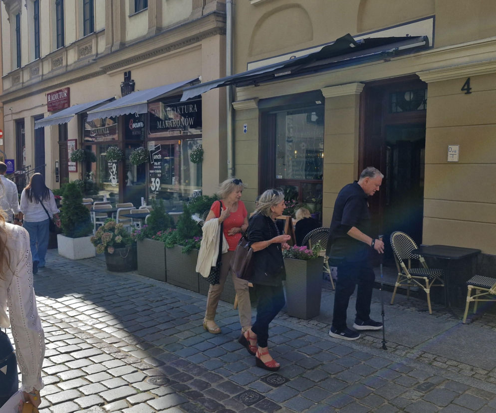 Ludzie spacerujący obok ogródków restauracyjnych w Toruniu. O testowaniu tanich dań przez SE przeczytasz w artykule.