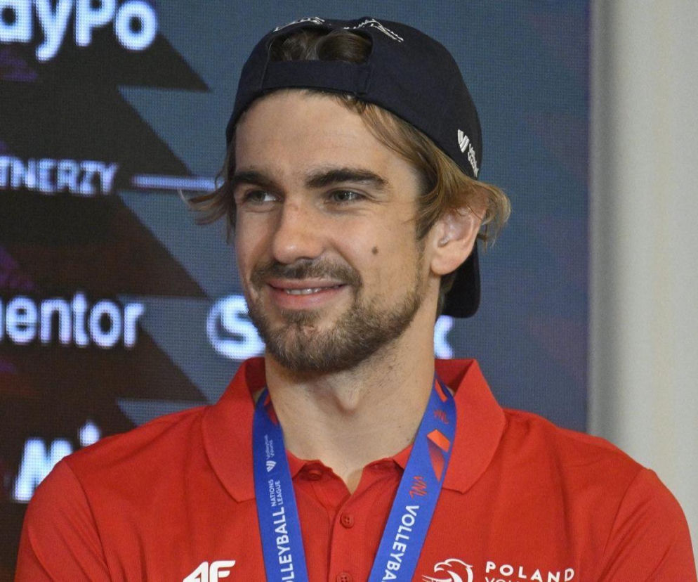 Uśmiechnięty siatkarz Jakub Popiwczak w czerwonej koszulce i czapce. O sukcesie w Lidze Narodów przeczytasz na SE Supersport.