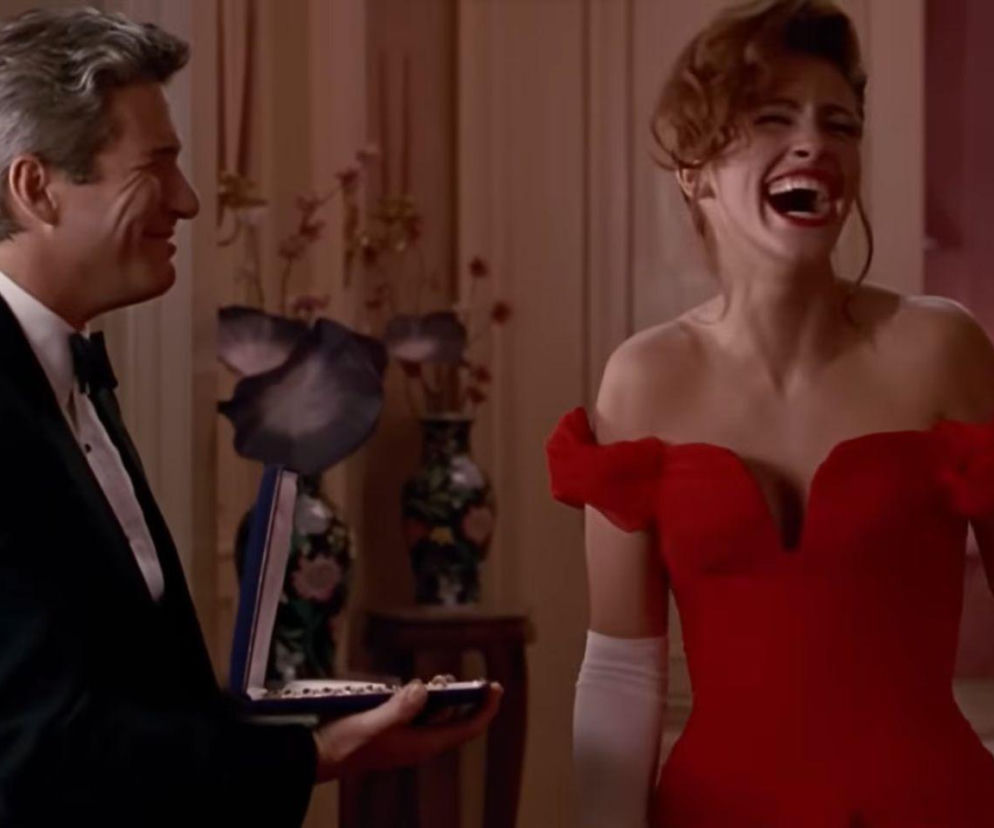 Uśmiechnięty Richard Gere trzyma etui z naszyjnikiem, a obok Julia Roberts śmieje się głośno. Oglądaj w EskaRock.