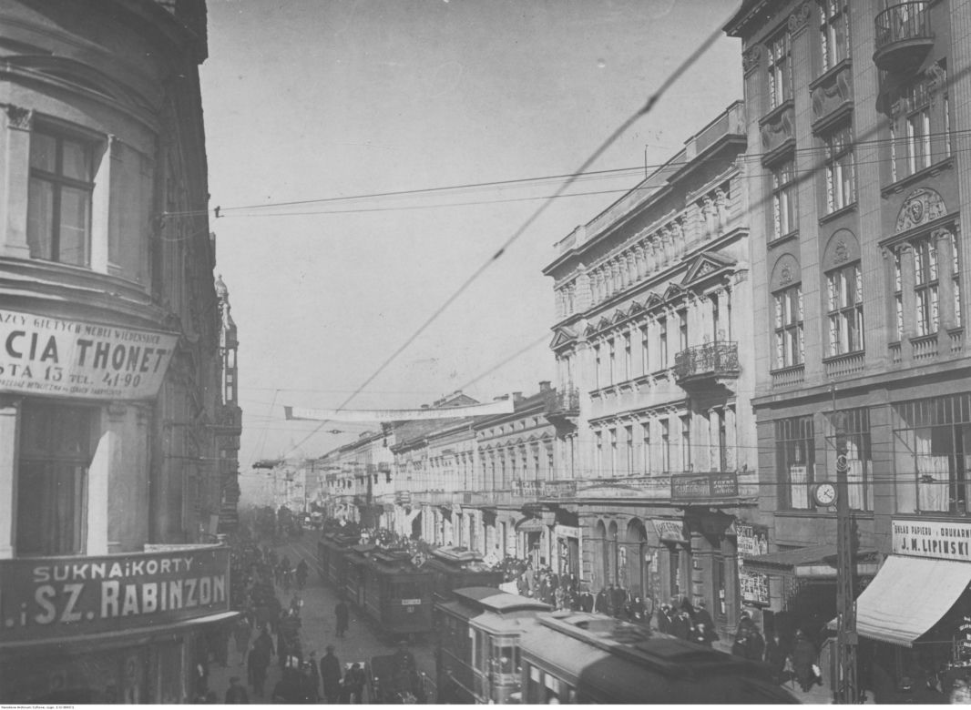 Fragment ulicy Piotrkowskiej. Na budynkach widoczne szyldy reklamowe, na ulicy jadące tramwaje, lata: 1920-1928