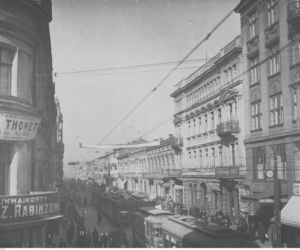 Fragment ulicy Piotrkowskiej. Na budynkach widoczne szyldy reklamowe, na ulicy jadące tramwaje, lata: 1920-1928