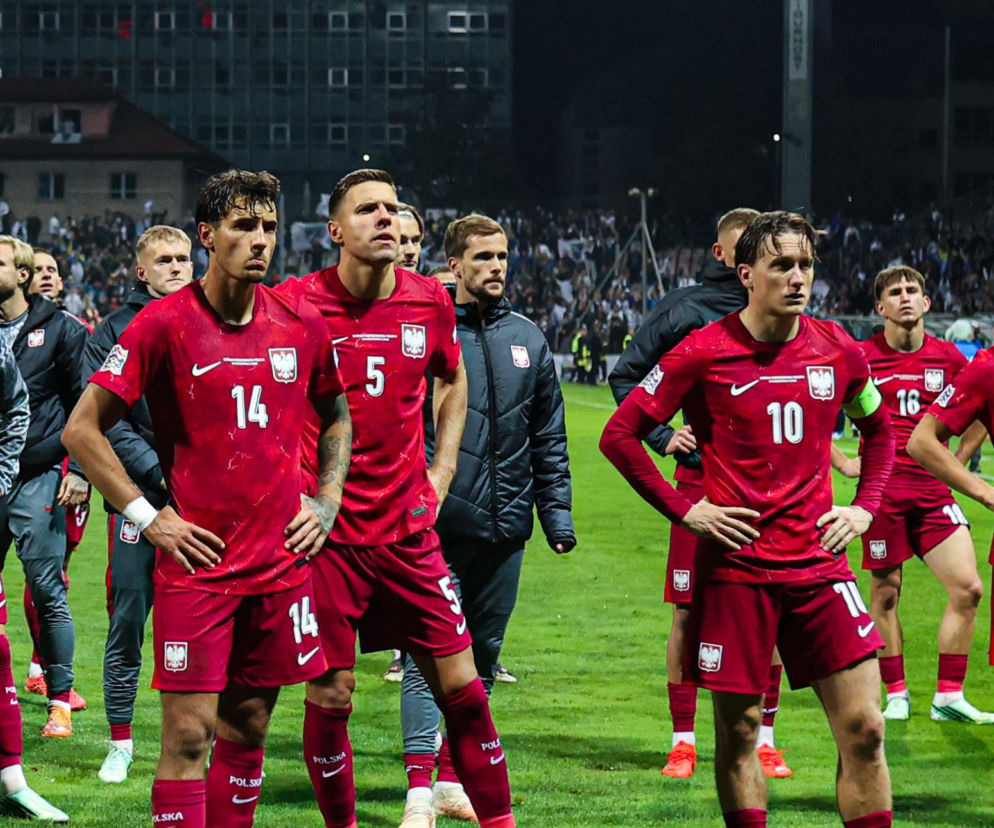 Zasmuceni polscy piłkarze w czerwonych strojach stoją na murawie boiska. O porażce z Bośnią przeczytasz na SE Supersport.