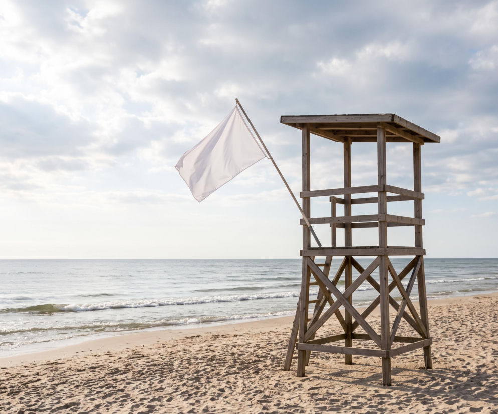 Drewniana wieża ratownika z białą flagą na plaży w Chłopach. O bezpiecznej kąpieli nad Bałtykiem czytaj w SE Szczecin.