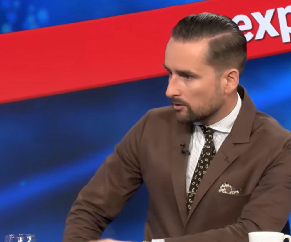 Dziennikarz Tomasz Żółciak w brązowej marynarce podczas dyskusji. O nowym sędzim TK przeczytasz na Mediateka.