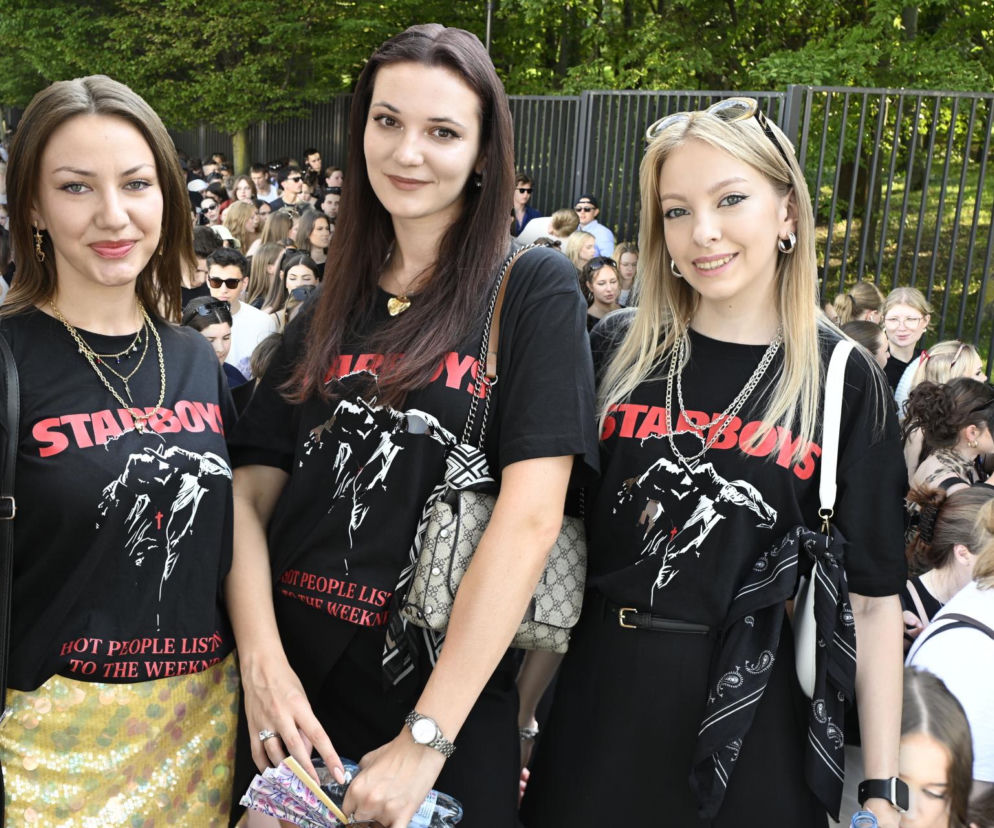 Trzy uśmiechnięte fanki w czarnych koszulkach z napisem Starboy pod PGE Narodowym. Relację przeczytasz na Eska Warszawa.