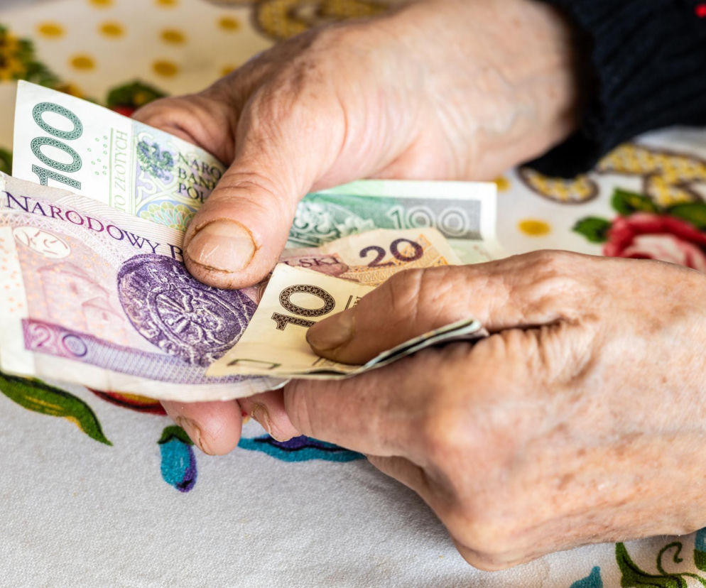 Dłonie seniorki przeliczającej banknoty 100, 20 oraz 10 złotych. O niskich emeryturach przeczytasz na SE Superbiz.