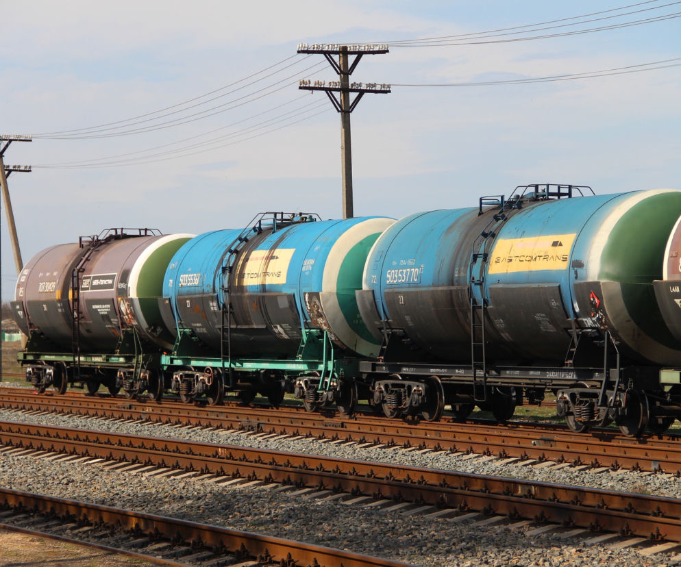 Cysterny towarowe na torach kolejowych, transportujące olej słonecznikowy, co w kontekście tekstu z Super Biznes podkreśla dominację Ukrainy w imporcie tego surowca do UE.