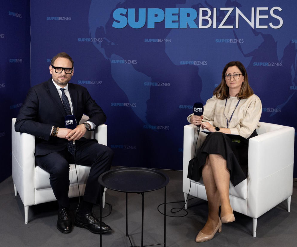 Szymon Paweł Moś, prezes Polskiej Spółki Gazownictwa, i Maria Olecha-Lisiecka podczas wywiadu w studiu Super Biznesu na Europejskim Kongresie Gospodarczym. Siedzą w białych fotelach na tle z logiem Super Biznes, trzymając mikrofony. Całość dostępna na Super Biznes.