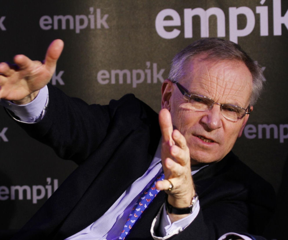 Pisarz Jeffrey Archer gestykuluje podczas spotkania autorskiego na tle logotypów Empik. O jego śmierci przeczytasz w Eska.
