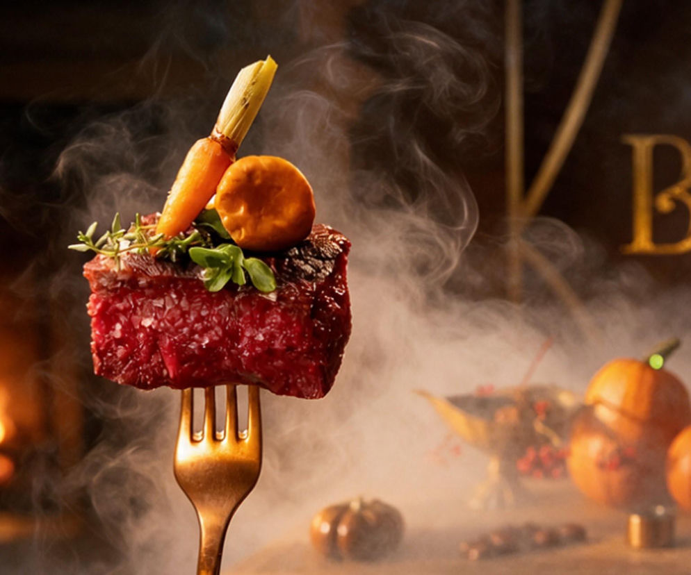 Kawałek mięsa z warzywami na widelcu w kłębach pary. O Bachleda Festiwalu Restauracji w Zakopanem przeczytasz na Eska Kraków.