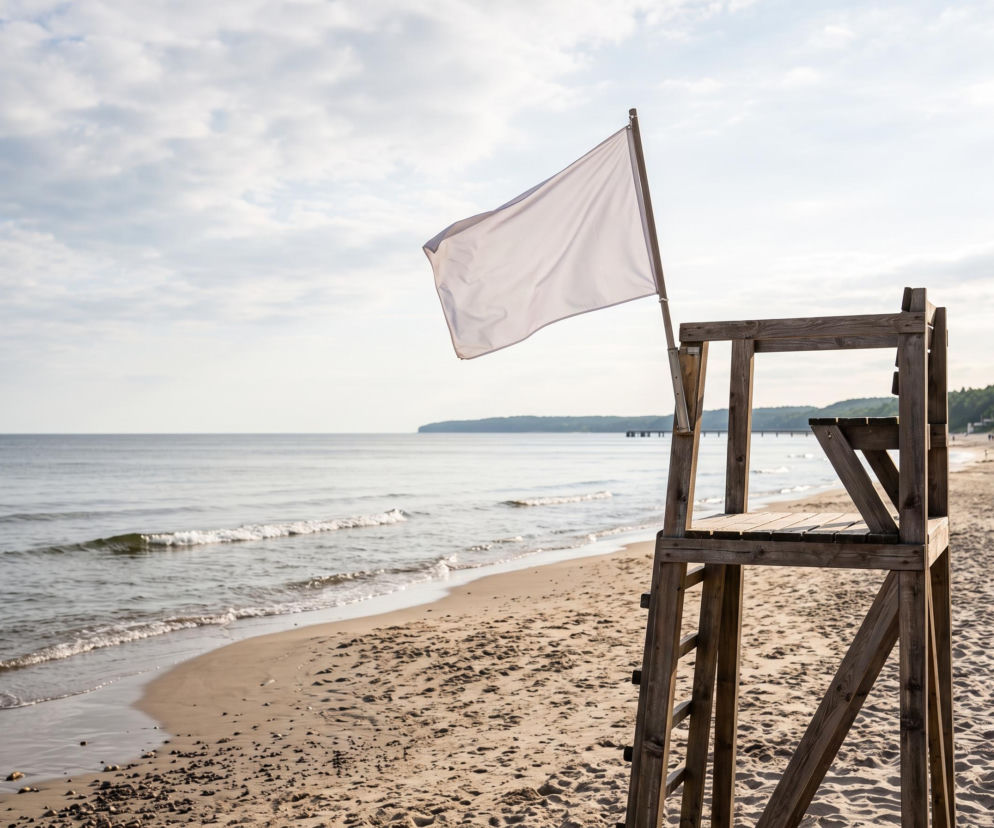 Biała flaga powiewa na wieży ratowniczej na pustej plaży w Międzyzdrojach. O bezpieczeństwie nad wodą przeczytasz w SE Szczecin.