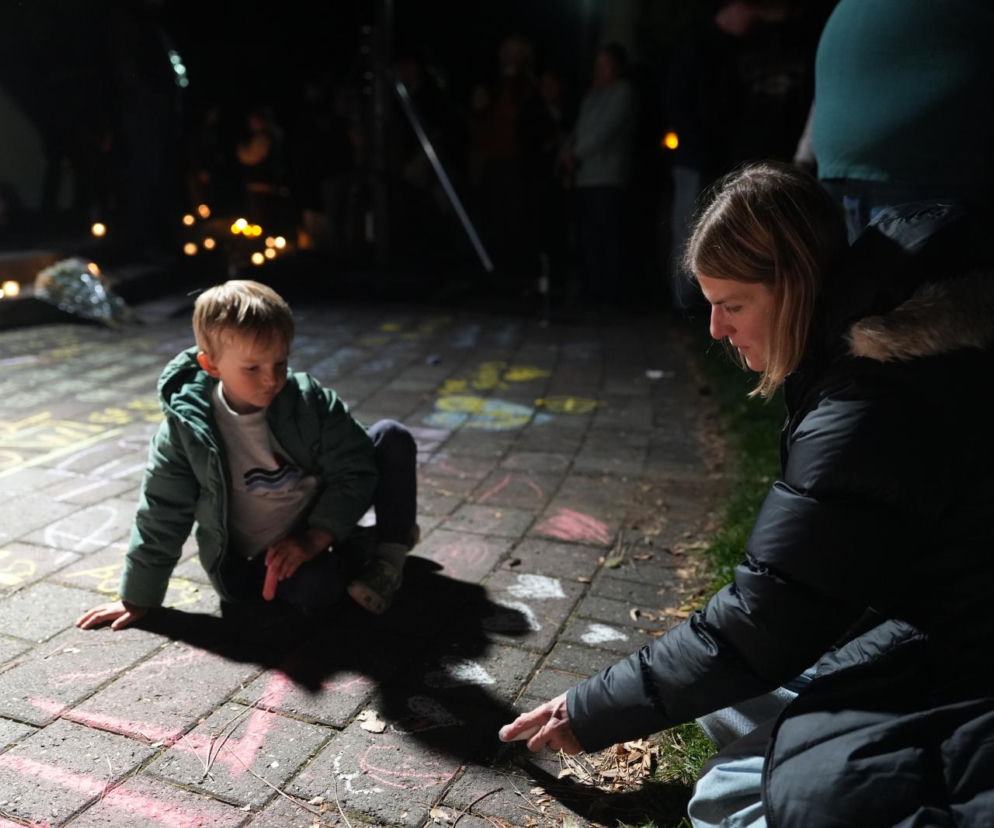 Kobieta i chłopiec przy napisach kredą na chodniku i zniczach. O tragedii w Oregonie przeczytasz w serwisie Eska.