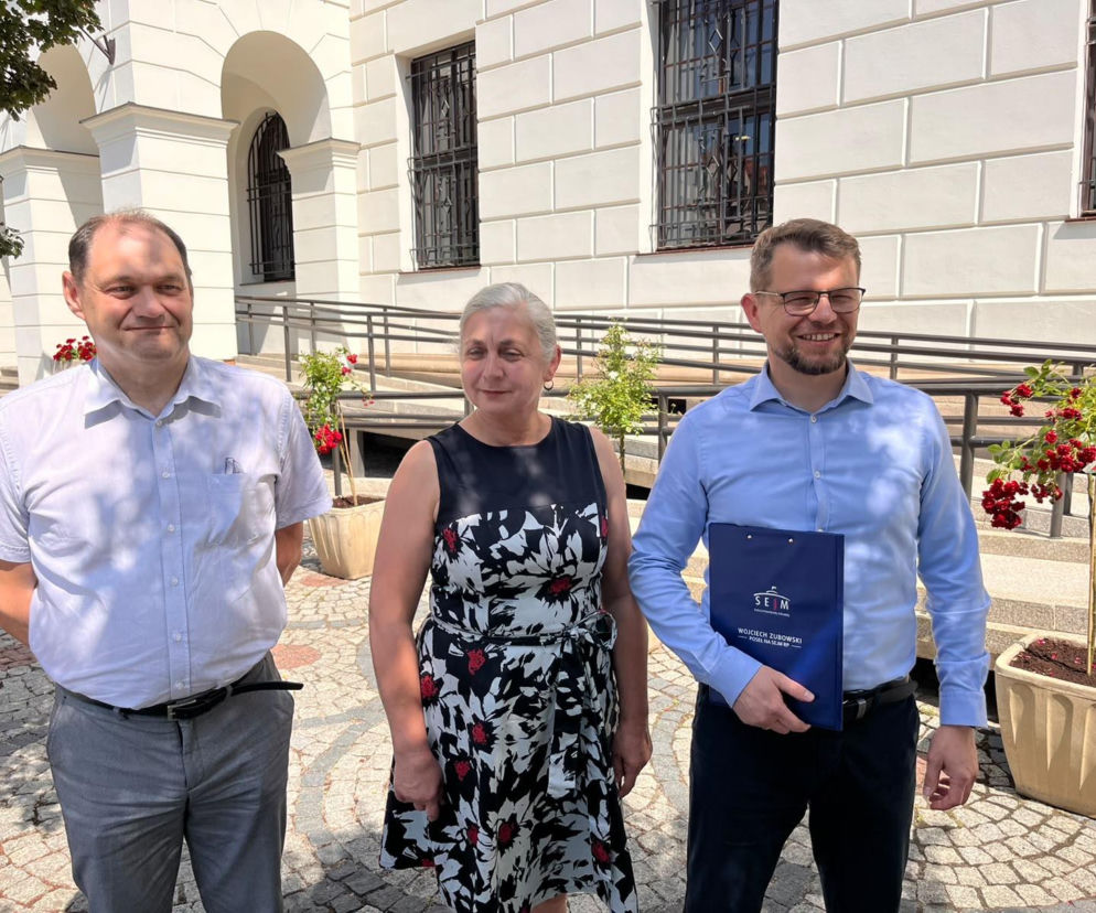 Troje radnych przed białym budynkiem. Jeden trzyma teczkę Sejmu. O sprawie majątku Głogowa przeczytasz na Radioplus.