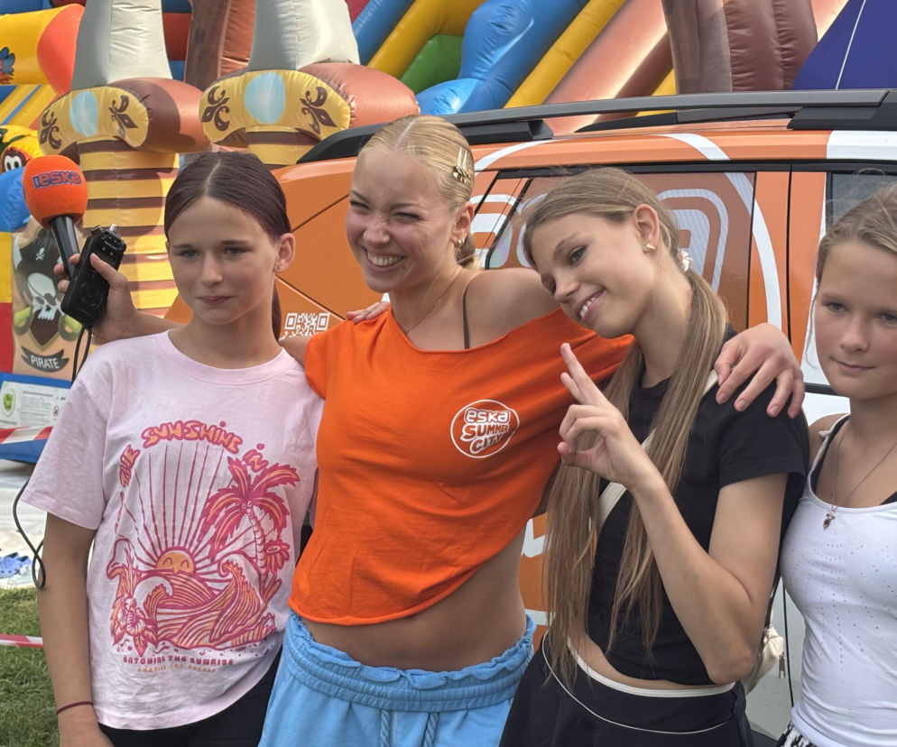 Cztery uśmiechnięte dziewczyny na tle radiowego auta i dmuchańców. O Eska Music Tour przeczytasz na Eska Olsztyn.