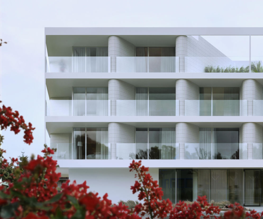 Biała elewacja hotelu Promenada II z przeszklonymi tarasami. O architekturze we Władysławowie przeczytasz na Architektura.