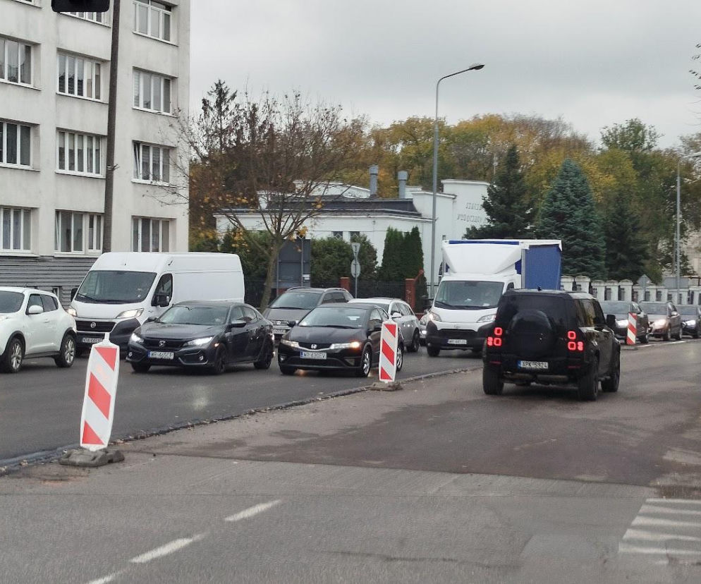 Sznur aut na zwężonej ulicy 25 czerwca w Radomiu obok biało-czerwonych słupków. O remontach przeczytasz w Eska Radom.