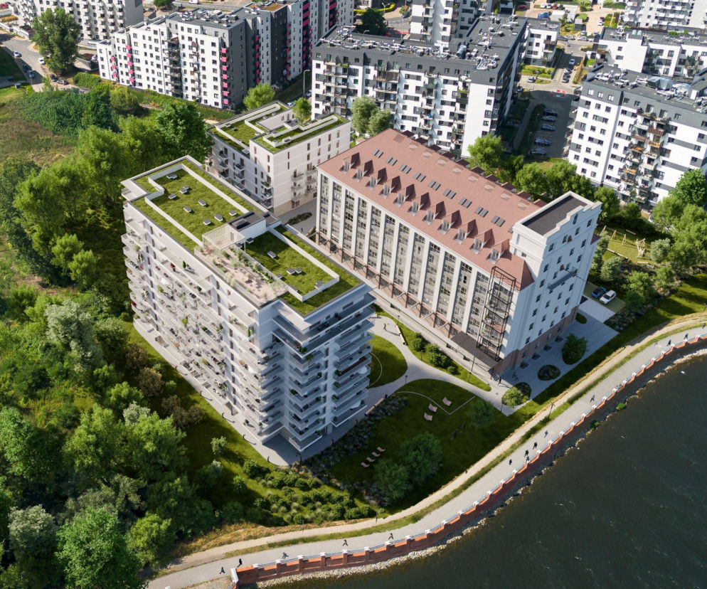 Wizualizacja projektu adaptacji elewatora zbożowego „Odra” we Wrocławiu na lofty i mieszkania. Prezentacja nowoczesnych budynków z zielonymi dachami i balkonami obok zrewitalizowanego elewatora, nad brzegiem wody z deptakiem. Więcej o adaptacji elewatorów przeczytasz na Architektura Murator Plus.