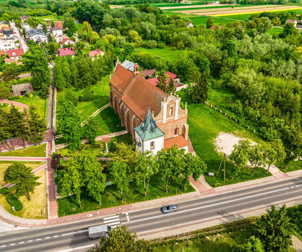 Widok z góry na kościół św. Trójcy w Nowym Korczynie przy drodze. O historii miasteczka przeczytasz na Eska Starachowice.