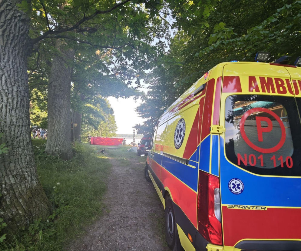 Ambulans na leśnej drodze prowadzącej do jeziora. O tragedii i śledztwie prokuratury przeczytasz na Eska Olsztyn.