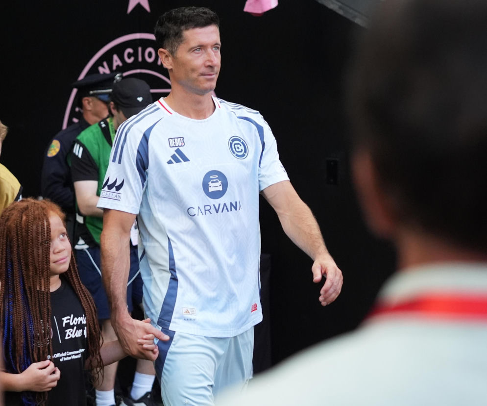 Robert Lewandowski w białym stroju Chicago Fire trzyma za rękę dziewczynkę. O meczu z Magnusem Lopezem czytaj w SE Supersport.