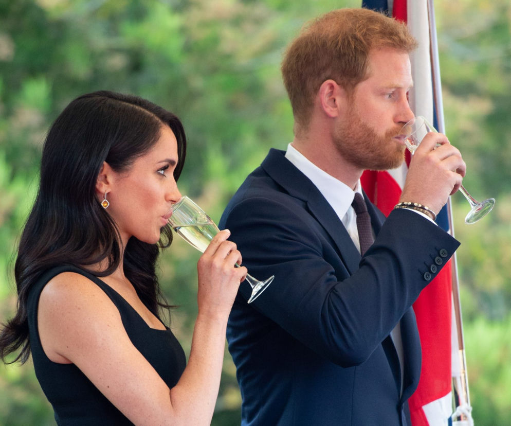 Książę Harry i Meghan Markle piją z kieliszków podczas uroczystości. O ich powrocie do Londynu przeczytasz na Eska.