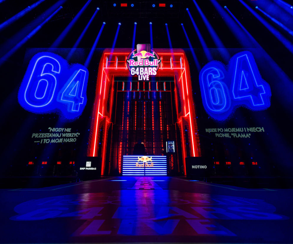 Scena Red Bull 64 Bars Live w Krakowie z wielkimi neonami 64 i logo. O rapowym widowisku przeczytasz w serwisie Eska.
