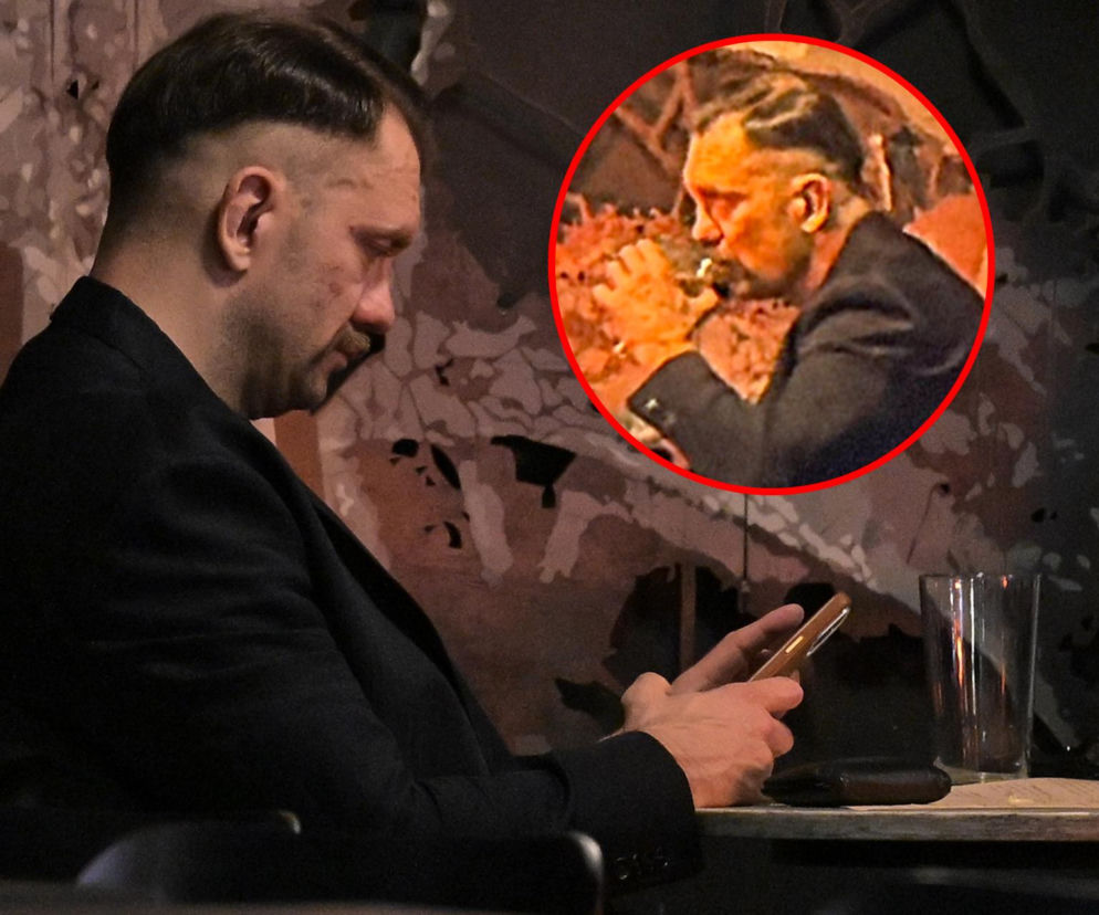 Poseł Łukasz Mejza siedzi w lokalu i patrzy w telefon. Na miniaturowym zdjęciu obok pije napój. O polityku czytaj na SE.