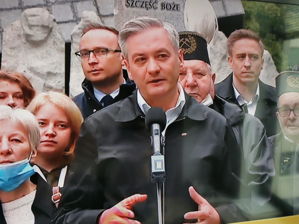 Robert Biedroń na tle religijnego hasła