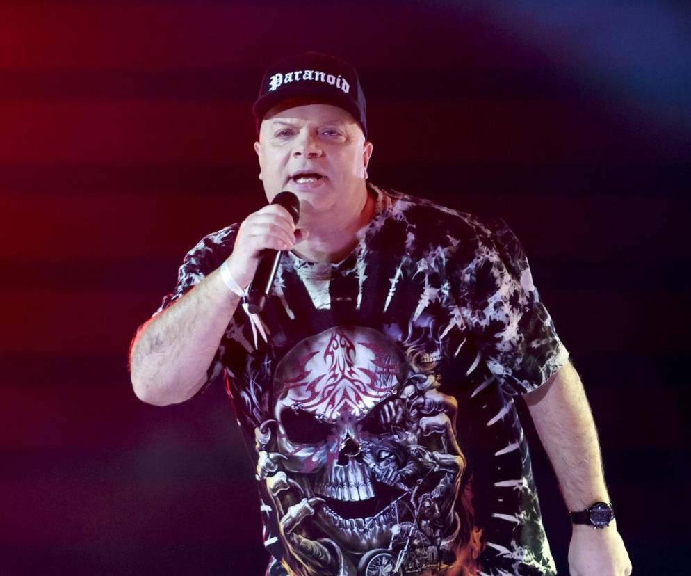 Krzysztof Skiba w koszulce z czaszką i czapce Paranoid śpiewa do mikrofonu. O przemianie lidera Big Cyca czytaj w EskaRock.